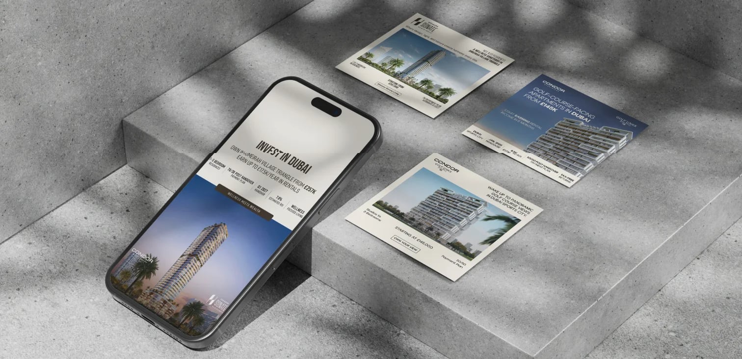 Phone showing “INVEST IN DUBAI” with flyers on concrete