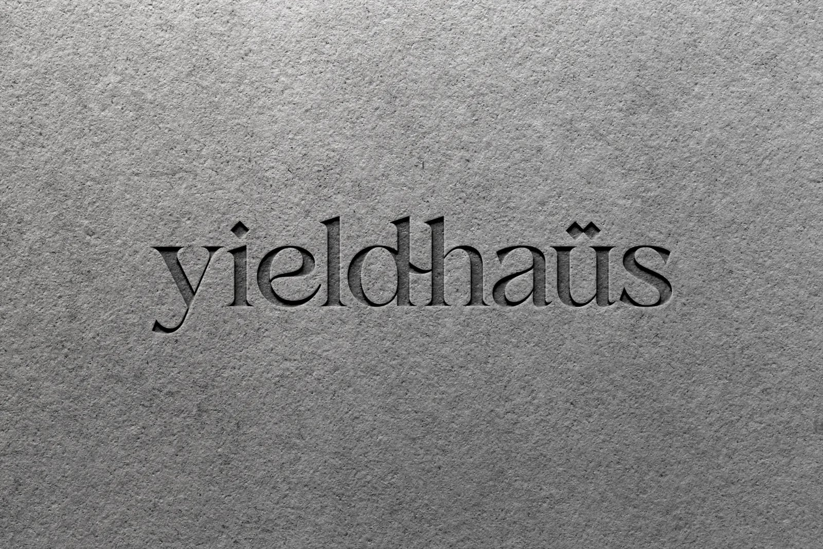 yieldhaüs wordmark carved in stone