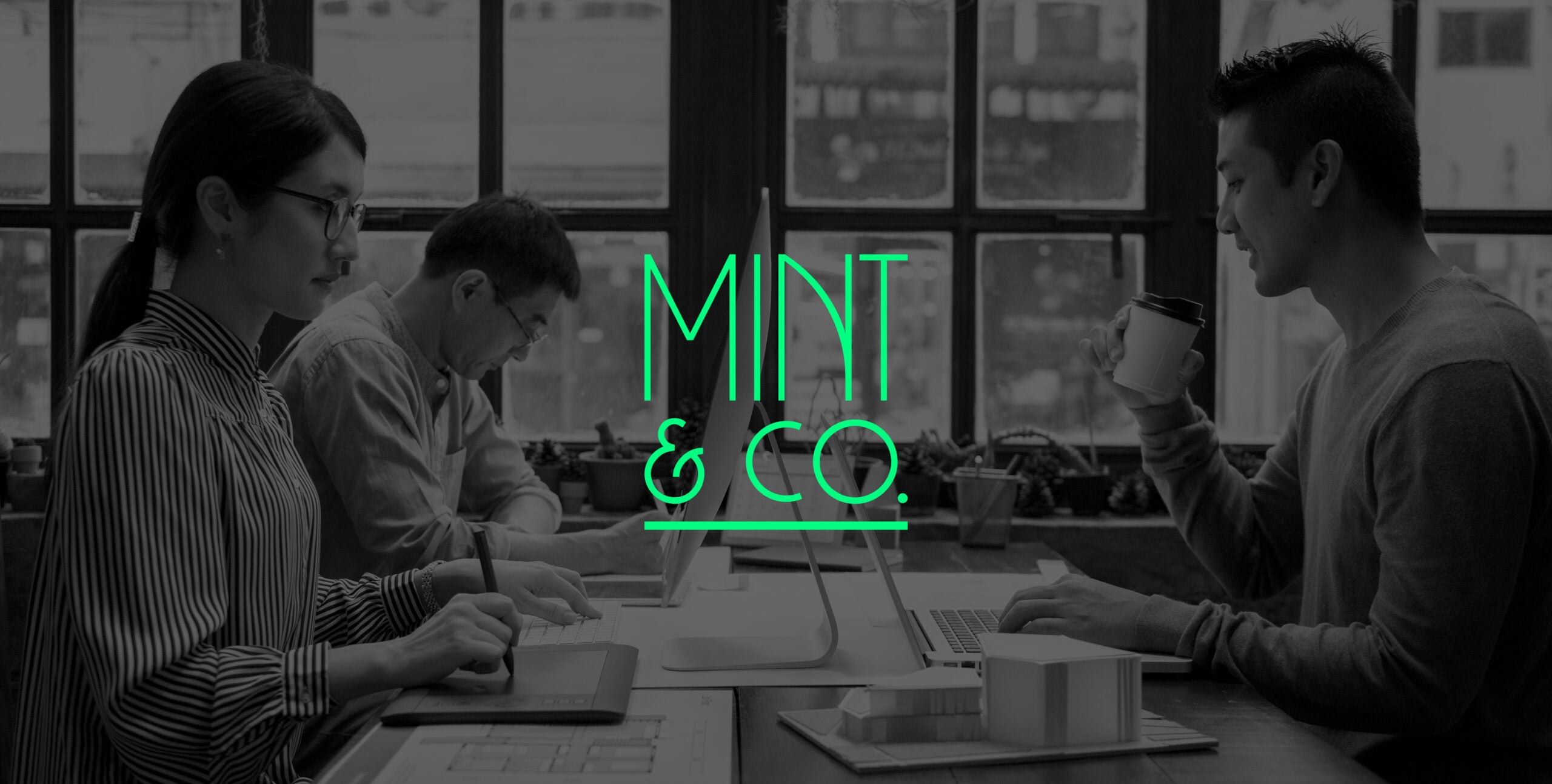 Mint & Co. creative team working at a shared desk