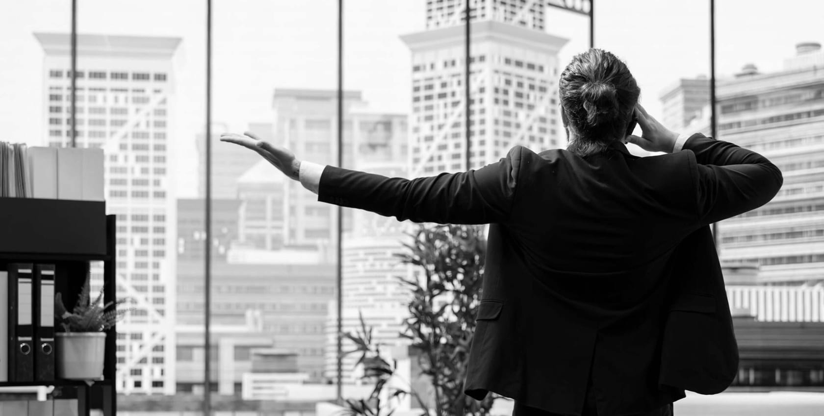 Businessman on a call by a city skyline, real estate business communication